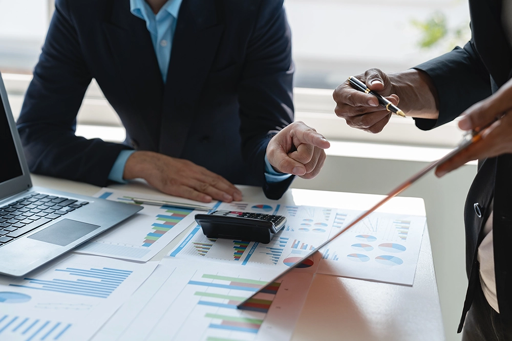 Investment advisor reviewing financial data charts and planning strategy with client