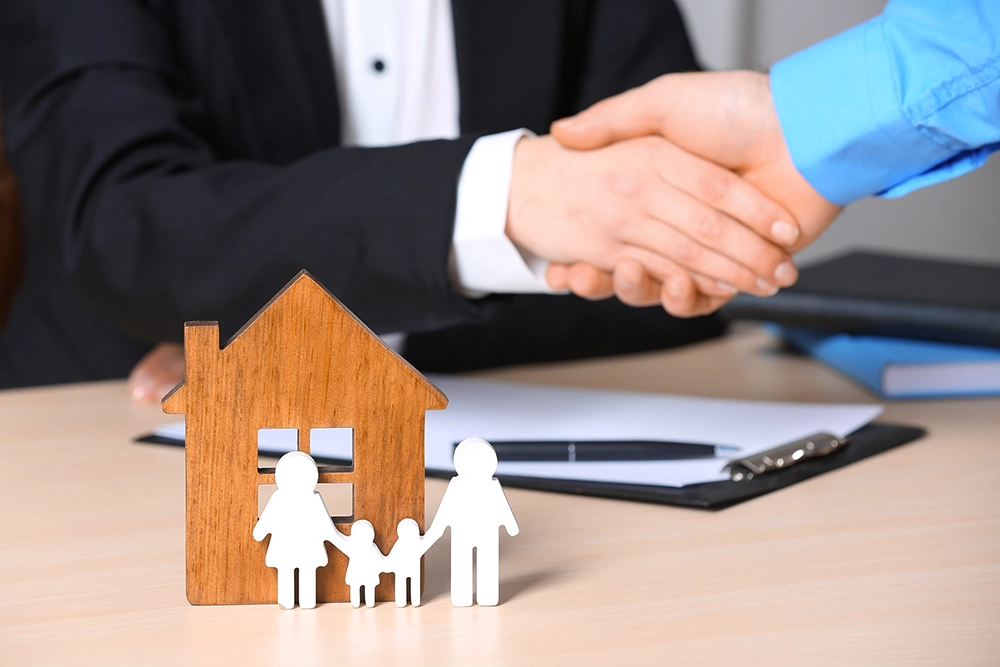 Financial advisor handshake with home model representing trusted investment planning in Canada